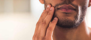 Man looking in the mirror to care for his beard