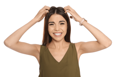 Young brunette woman in brown shirt grimacing over her sensitive scalp