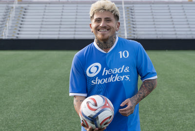 Diego Luna with blonde hair holds a soccer on a soccer field, showing the confidence after using Head & Shoulders, the world’s #1 anti-dandruff shampoo, as his dandruff treatment.